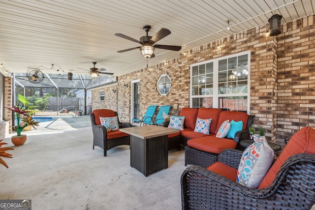 view of patio featuring an outdoor hangout area, ceiling fan, and glass enclosure