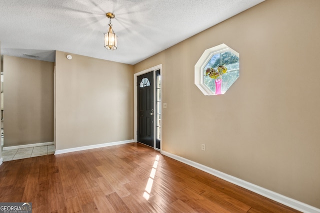 entrance foyer featuring a textured ceiling and light hardwood / wood-style flooring