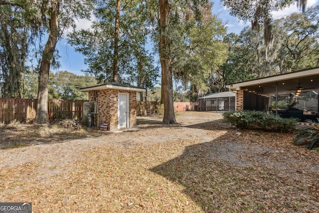 view of yard featuring ceiling fan and a storage unit