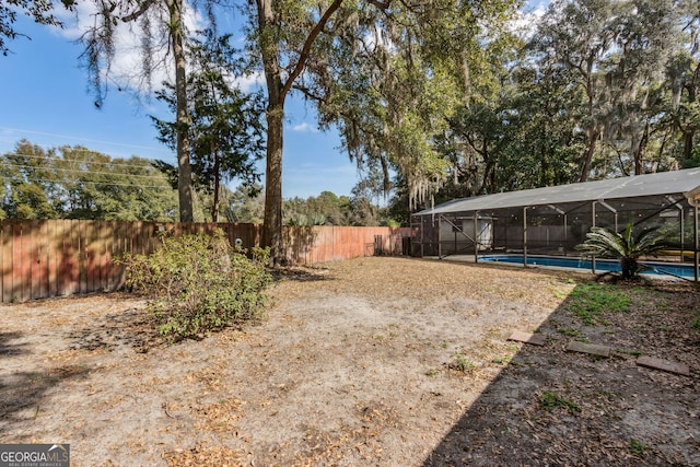 view of yard with a fenced in pool and a lanai