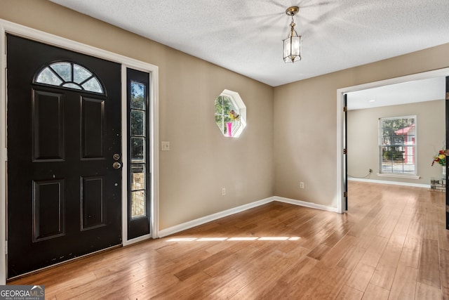 entrance foyer with a textured ceiling and light wood-type flooring