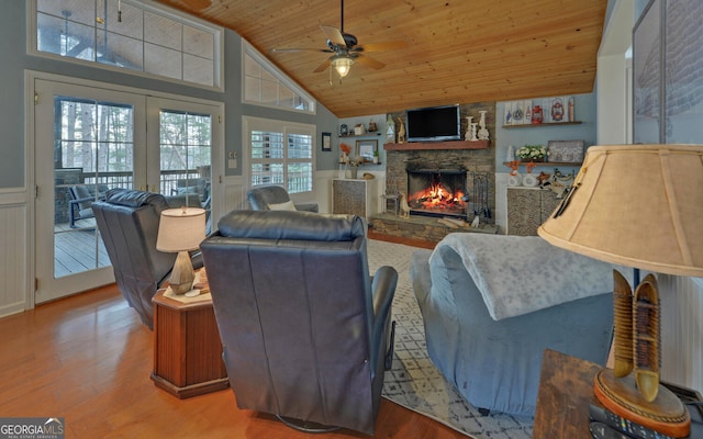 living room with wood ceiling, high vaulted ceiling, hardwood / wood-style flooring, ceiling fan, and a fireplace