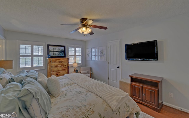 bedroom featuring ceiling fan, a textured ceiling, and light hardwood / wood-style flooring