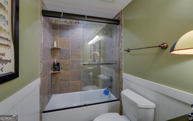 bathroom with shower / bath combination with glass door and toilet