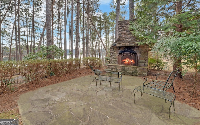 view of patio / terrace featuring a water view and an outdoor stone fireplace