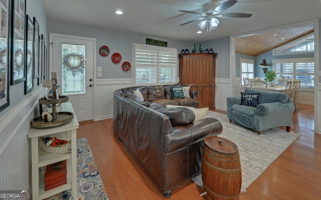 living room with ceiling fan, lofted ceiling, and light wood-type flooring