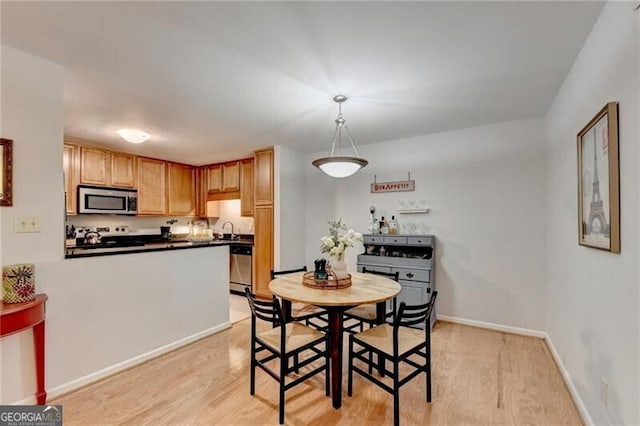 dining area with sink and light wood-type flooring