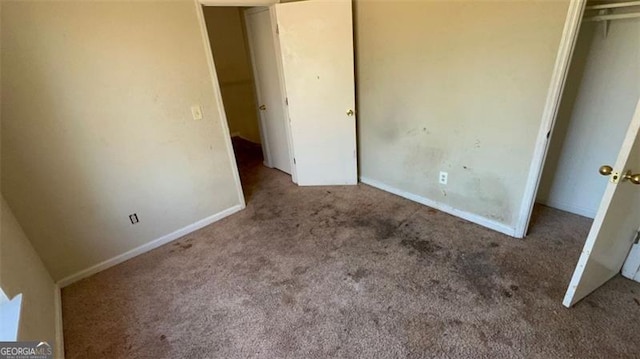 unfurnished bedroom with light colored carpet and a closet