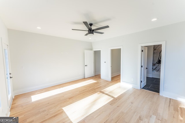 unfurnished bedroom featuring ensuite bathroom, ceiling fan, and light wood-type flooring