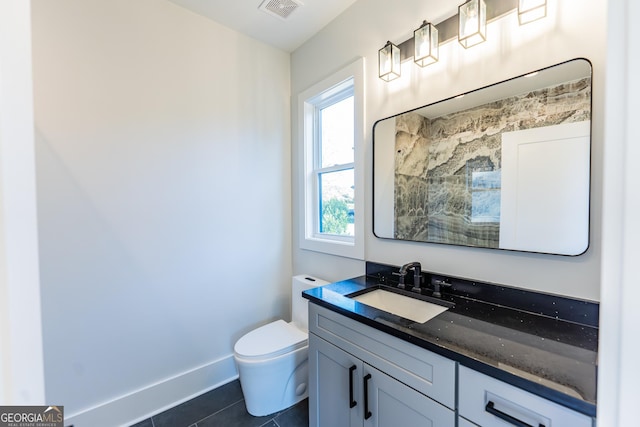 bathroom featuring vanity, tile patterned flooring, and toilet