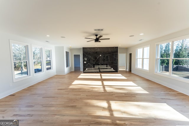 unfurnished living room featuring ceiling fan and light hardwood / wood-style flooring