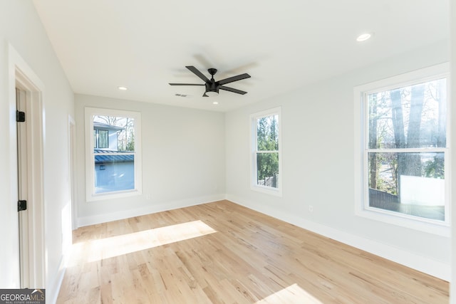 spare room featuring ceiling fan, a healthy amount of sunlight, and light hardwood / wood-style floors