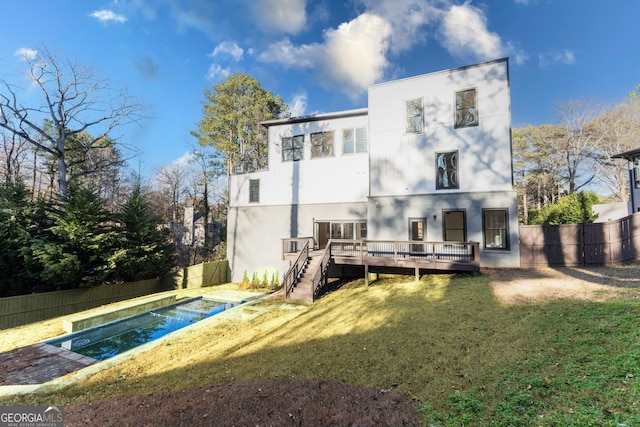 back of house featuring a pool side deck and a lawn