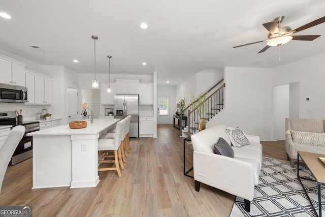 kitchen featuring stainless steel appliances, light wood-style floors, visible vents, and open floor plan