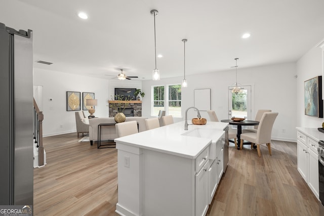 kitchen featuring light wood-type flooring, a healthy amount of sunlight, and a fireplace