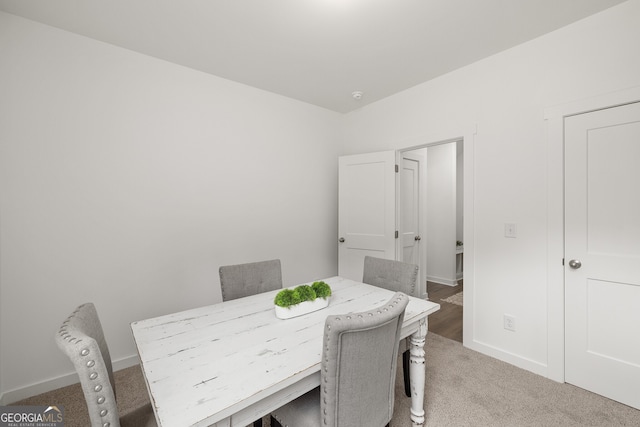 dining area featuring baseboards and light carpet