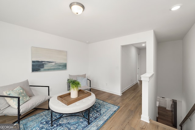 living area featuring recessed lighting, baseboards, and wood finished floors