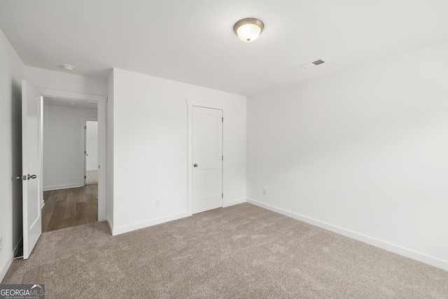 unfurnished bedroom featuring carpet flooring, baseboards, and visible vents