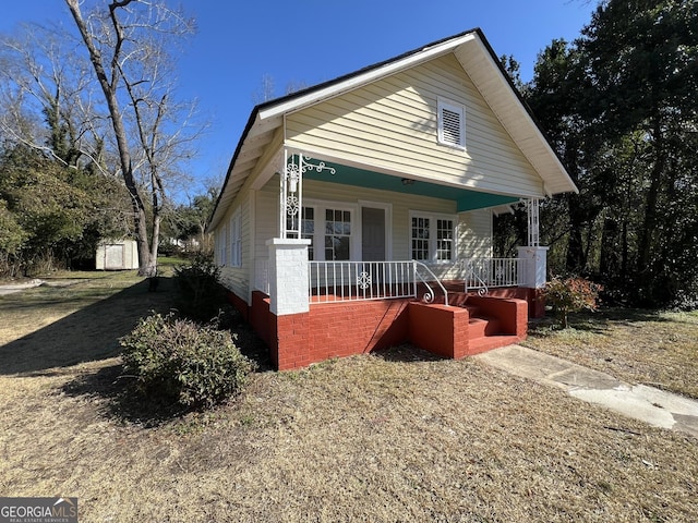 view of front facade with a storage shed and covered porch