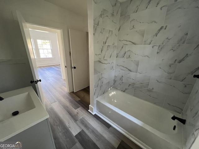 bathroom featuring tiled shower / bath, vanity, and hardwood / wood-style floors