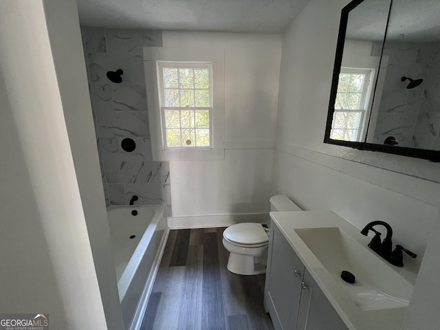 full bathroom featuring vanity, toilet, tiled shower / bath combo, and hardwood / wood-style floors