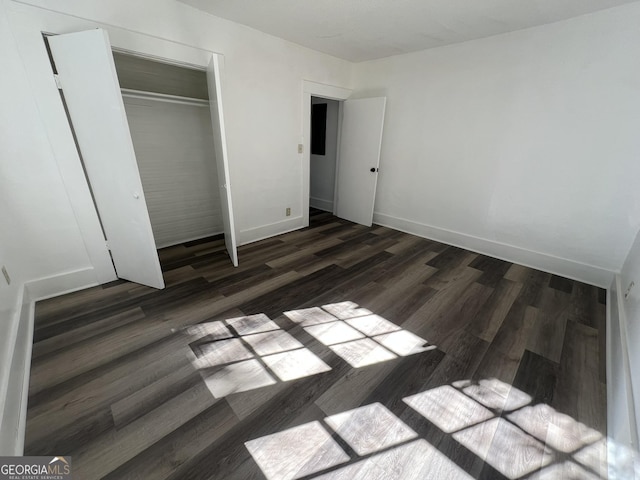 unfurnished bedroom featuring dark hardwood / wood-style floors and a closet