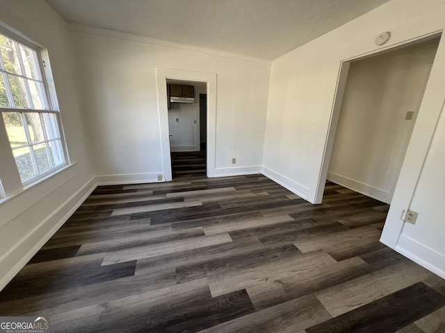 spare room with crown molding and dark hardwood / wood-style flooring