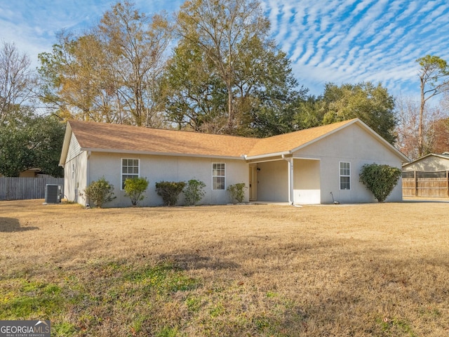 view of front of house with cooling unit and a front lawn