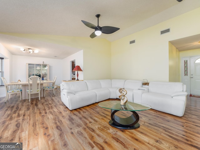 living room with wood-type flooring, ceiling fan, and vaulted ceiling