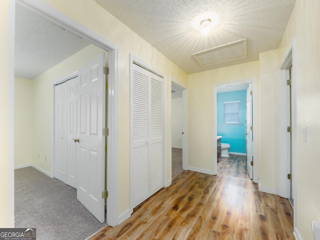 hall with hardwood / wood-style flooring and a textured ceiling