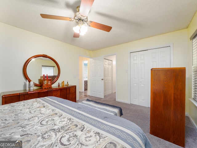 bedroom with ceiling fan, carpet floors, a closet, and a textured ceiling