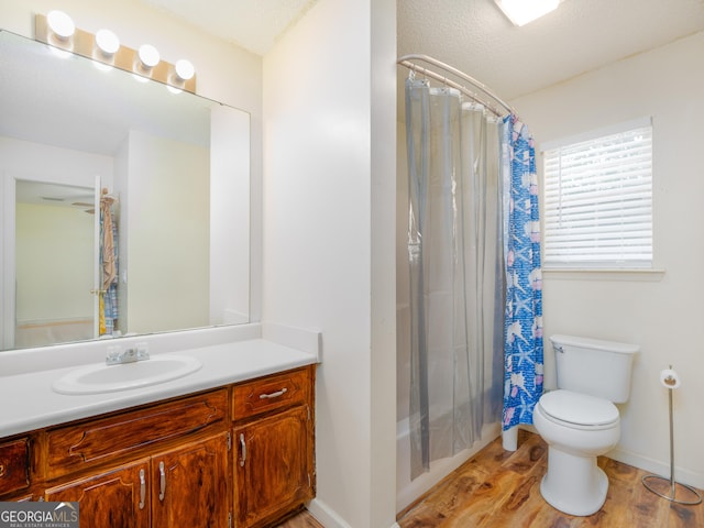 full bathroom with vanity, hardwood / wood-style floors, shower / tub combo, and toilet