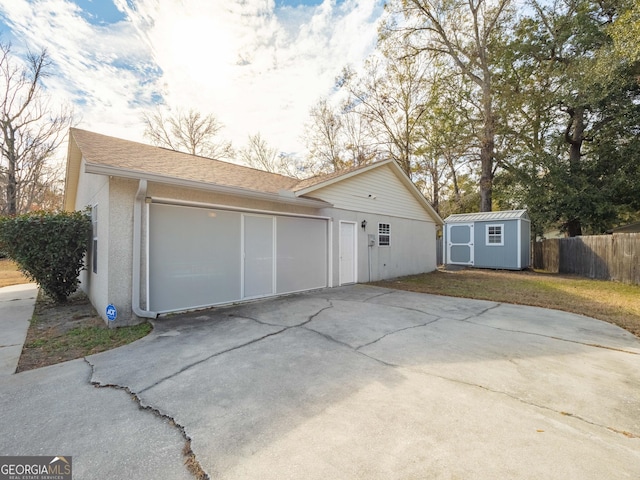 view of side of home with a garage and a storage shed