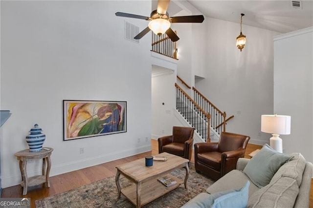 living room with ceiling fan, high vaulted ceiling, and hardwood / wood-style floors