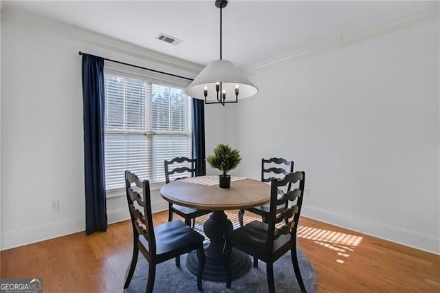 dining space featuring an inviting chandelier and light hardwood / wood-style floors