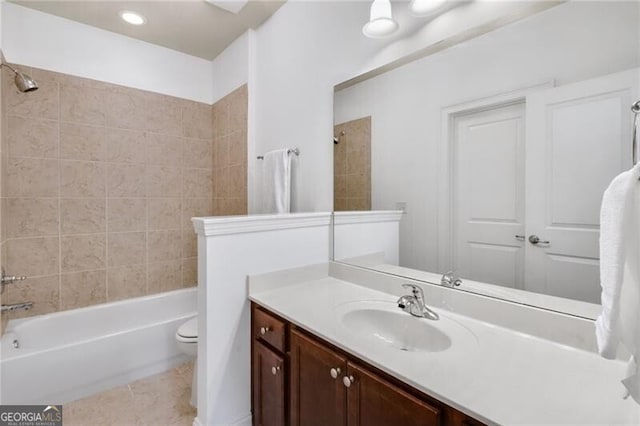 full bathroom with tiled shower / bath combo, vanity, tile patterned flooring, and toilet