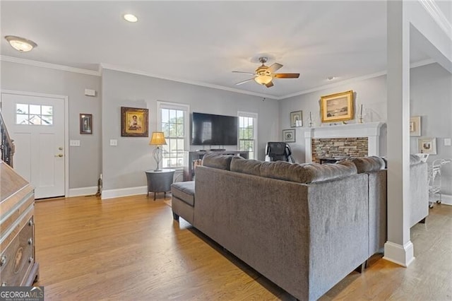 living room with light hardwood / wood-style flooring, a fireplace, and ornamental molding