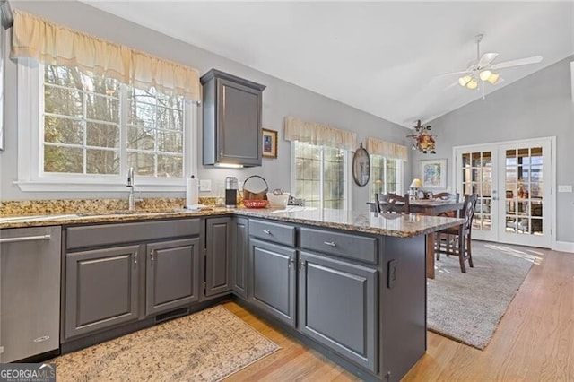 kitchen featuring stone counters, sink, stainless steel dishwasher, kitchen peninsula, and french doors