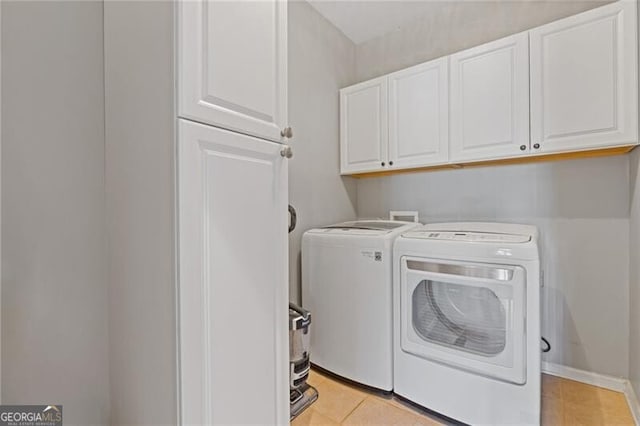 laundry area with cabinets, washer and dryer, and light tile patterned floors