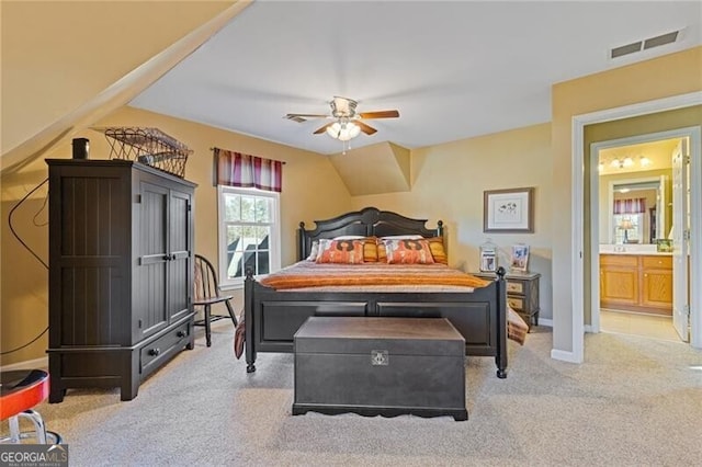 carpeted bedroom featuring vaulted ceiling, ensuite bathroom, and ceiling fan