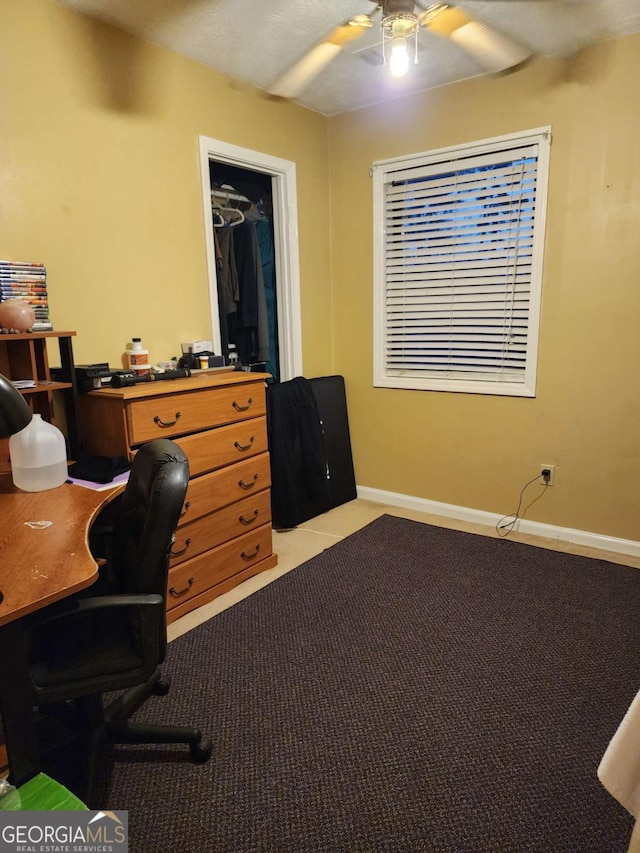 carpeted office space featuring ceiling fan