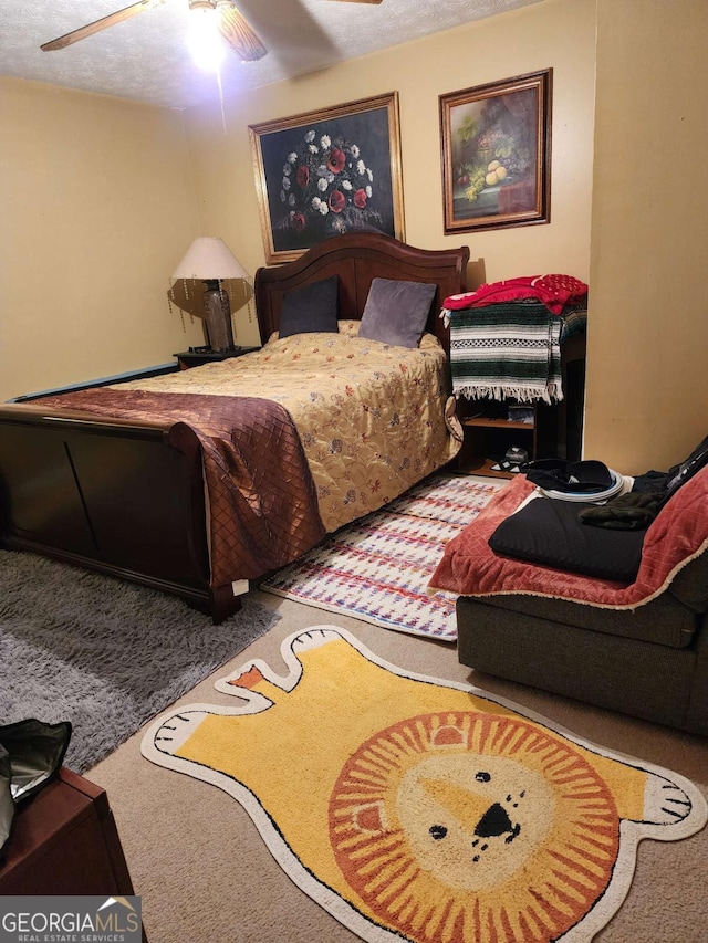 bedroom with a textured ceiling, ceiling fan, and carpet