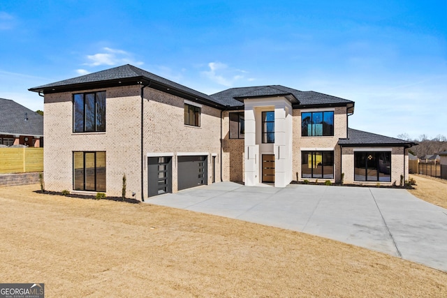 view of front facade with a garage, driveway, fence, a front lawn, and brick siding