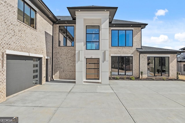 view of front facade featuring a garage, brick siding, and driveway