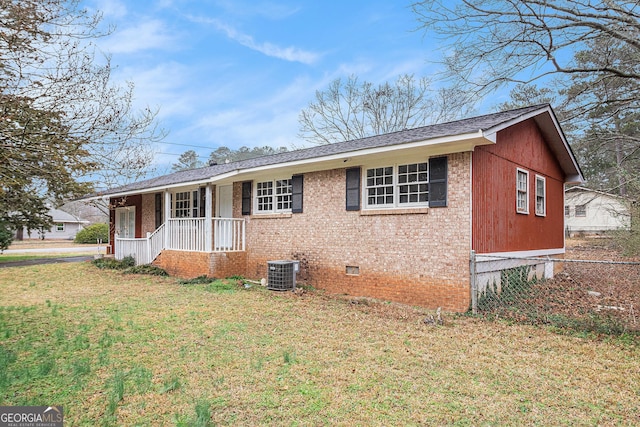 view of front of house featuring central AC, covered porch, and a front yard