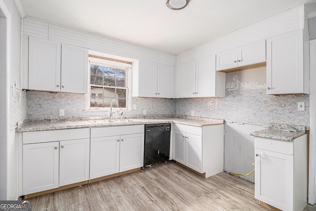 kitchen with sink, white cabinetry, tasteful backsplash, light hardwood / wood-style flooring, and black dishwasher