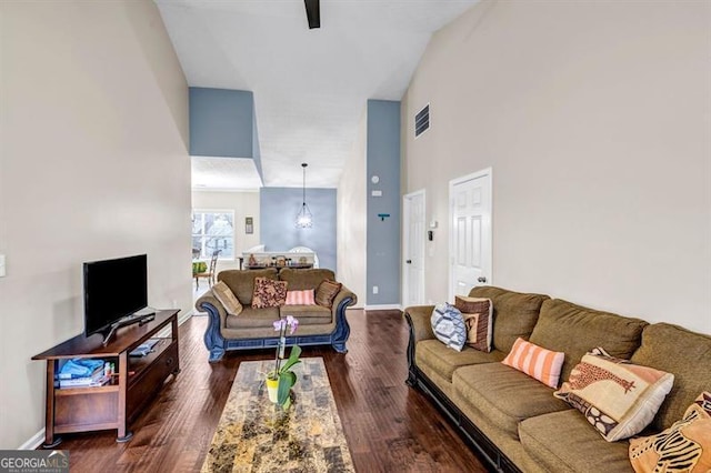 living room featuring a high ceiling and dark hardwood / wood-style floors