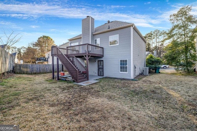 back of house with a wooden deck, a yard, and central air condition unit
