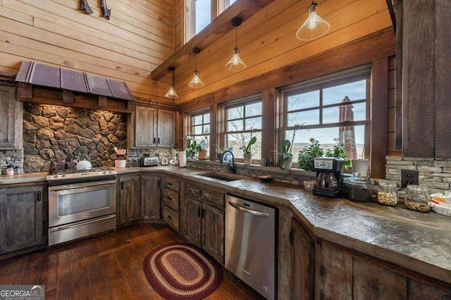 kitchen with sink, hanging light fixtures, dark brown cabinets, stainless steel appliances, and custom exhaust hood