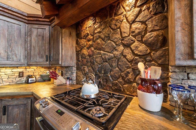 kitchen with dark brown cabinetry and stainless steel range with gas stovetop